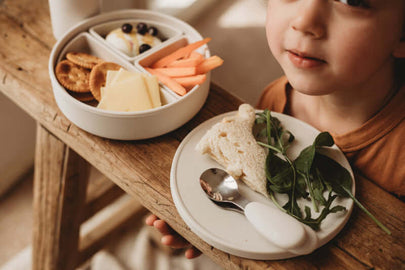 Child enjoying a meal with a 5 Piece Silicone Multifunctional Plate with Dividers & Lid.