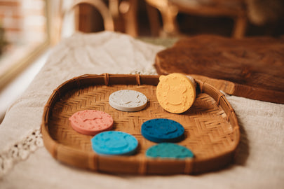 Colourful stampers on a woven tray with a blurred background