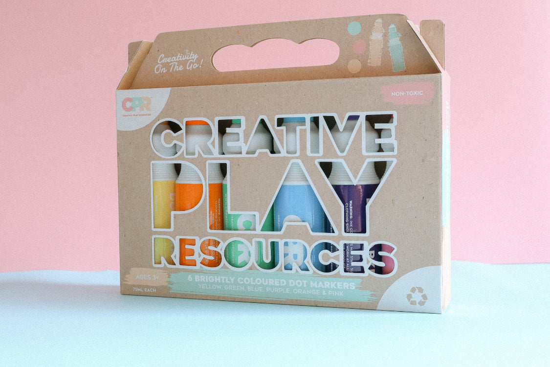 6 Dot markers in recycled packaging box standing upright with a pink pastel background.