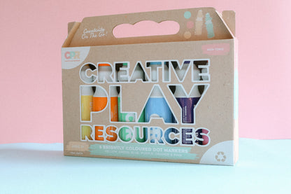6 Dot markers in recycled packaging box standing upright with a pink pastel background.