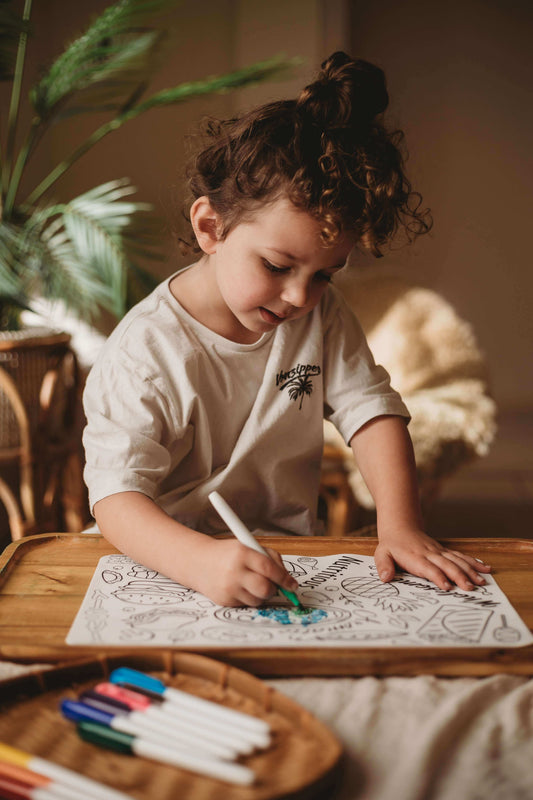 child drawing on reusable mat