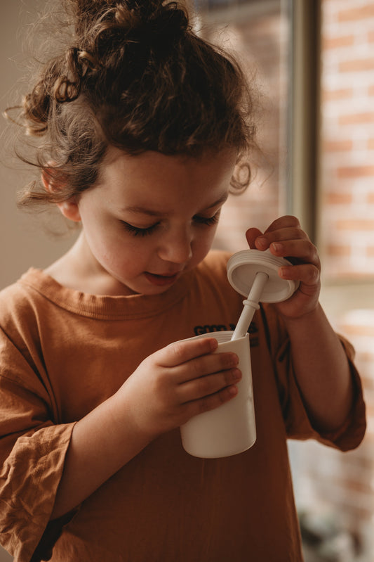 child holding a sippy cup