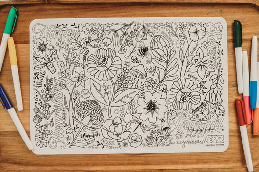 Mindful colouring benefits illustrated on a detailed black and white floral coloring page surrounded by colored markers.