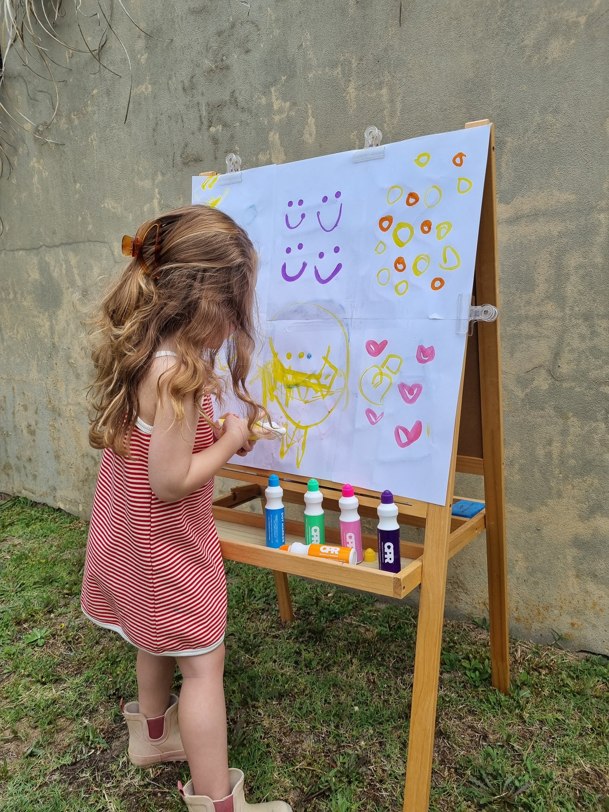 girl painting with CPR dot markers