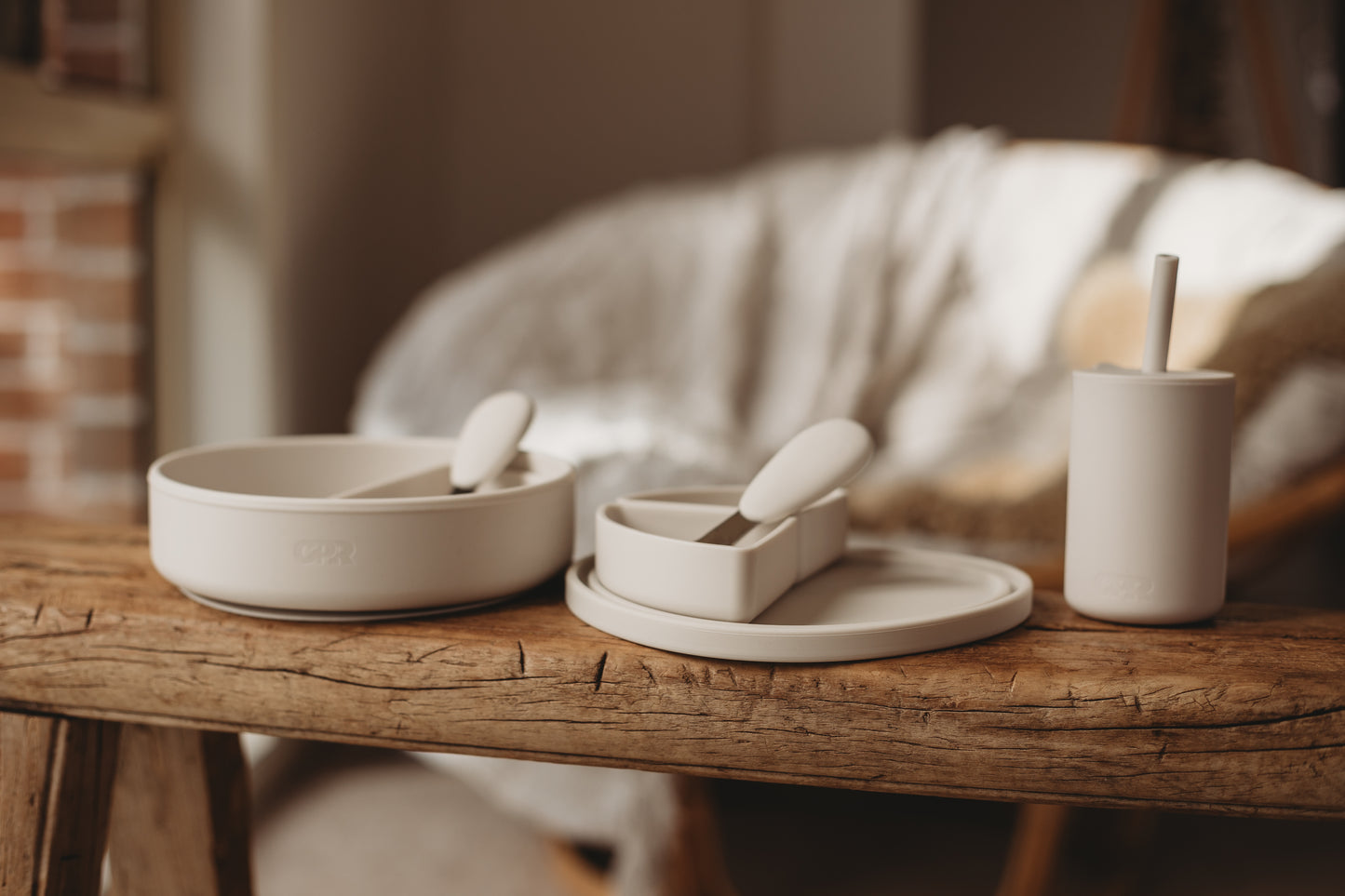 Set of ceramic bowls and cups on a wooden table with a blurred background