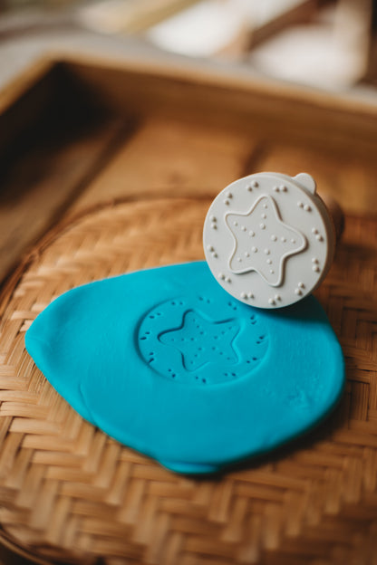 Star-shaped cookie stamp with blue dough 