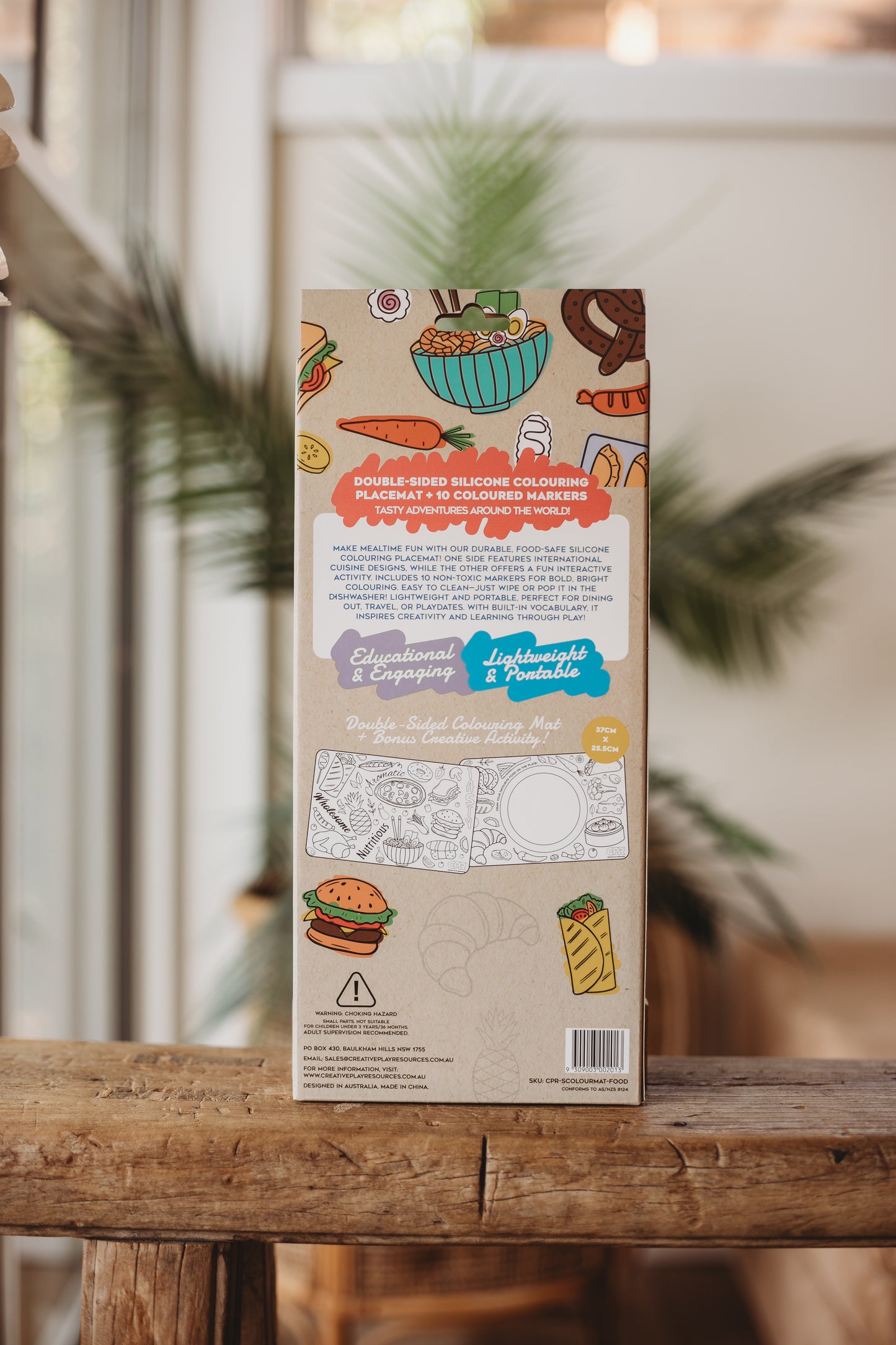Coloring book packaging on a wooden surface with a blurred indoor background