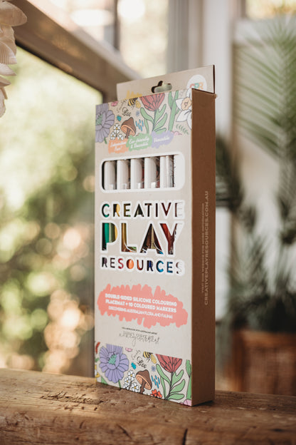 Box of 'Creative Play Resources'  floral colouring design on a wooden surface with a blurred natural background