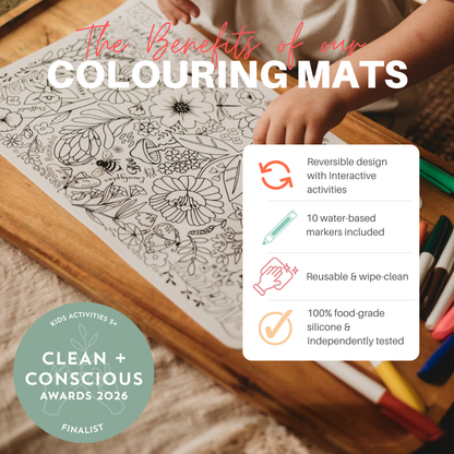A promotional graphic for a children's colouring mat showing a hand coloring a black-and-white floral design on a wooden table. Large text reads 'The Benefits of our COLOURING MATS,' with feature callouts in a white box and a 'Clean + Conscious Awards 2026 Finalist' badge.
